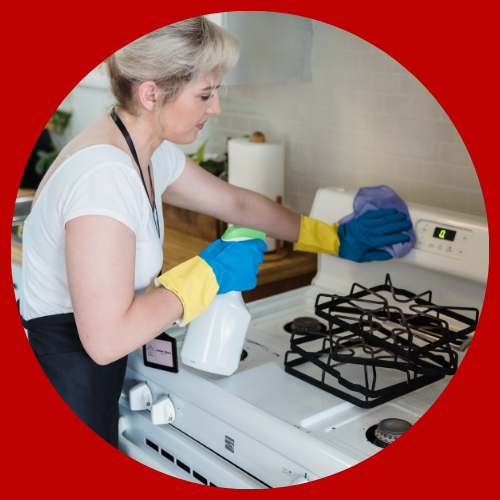 WOMAN CLEANING STOVE
